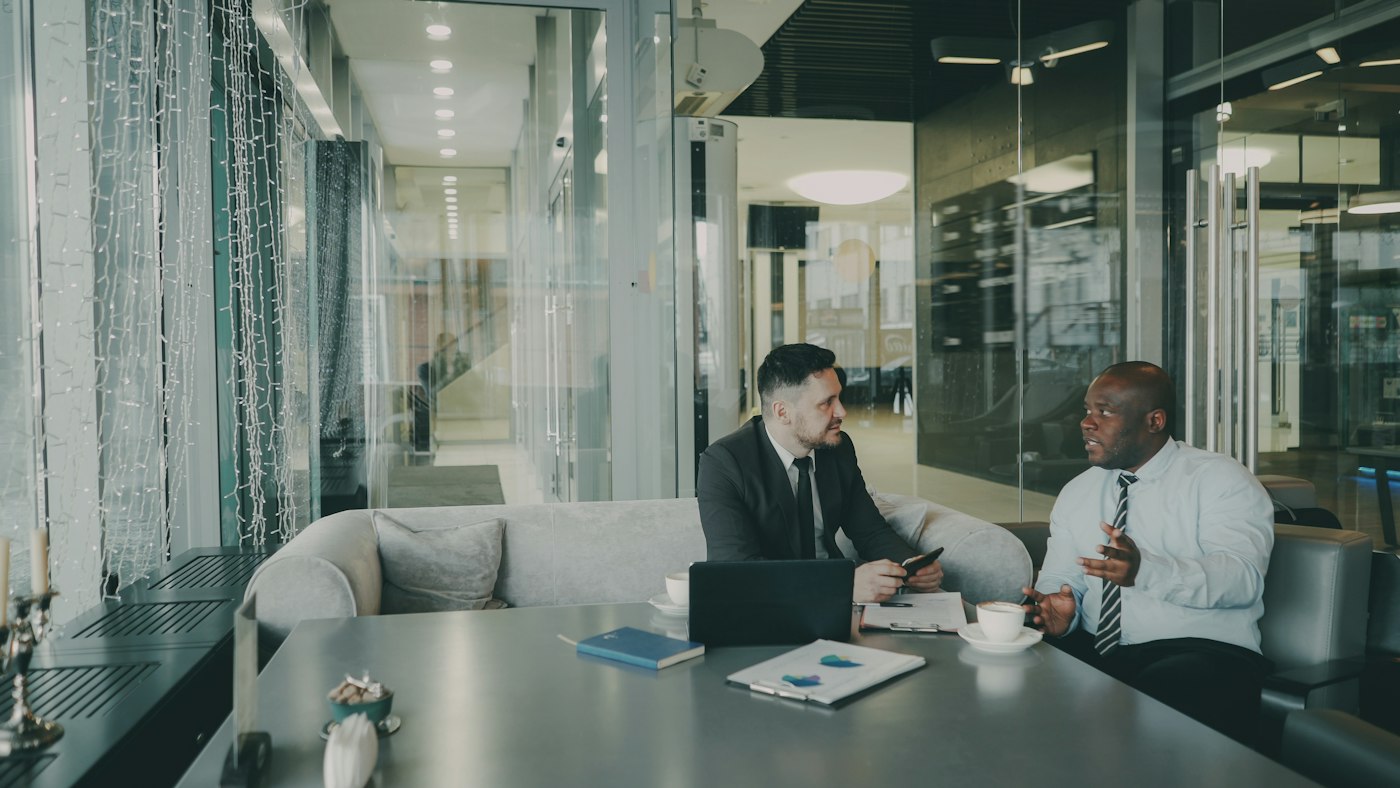 Two executives in conversation in a meeting room